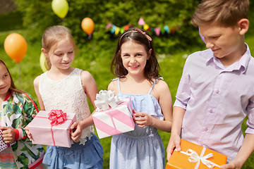 Image showing happy kids with gifts on birthday party in summer