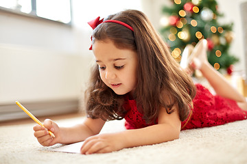 Image showing little girl writing christmas wish list at home