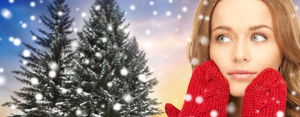 Image showing close up of woman in mittens over christmas tree