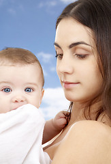 Image showing mother with baby in bath towel over sky background