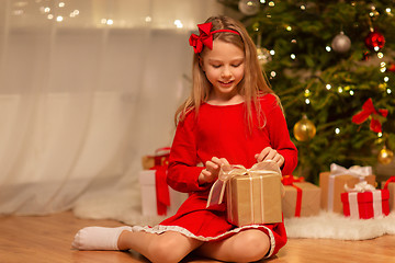 Image showing smiling girl with christmas gift at home