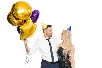 Image showing happy couple with party caps and balloons