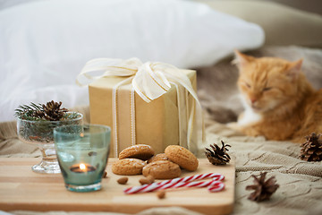 Image showing christmas gift, cookies and cat lying in bed