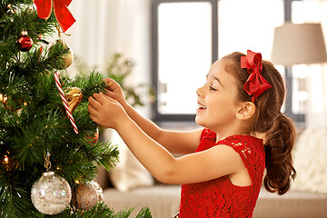 Image showing little girl decorating christmas tree at home