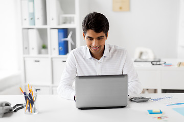 Image showing businessman with laptop and papers at office