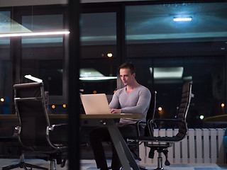 Image showing man working on laptop in dark office