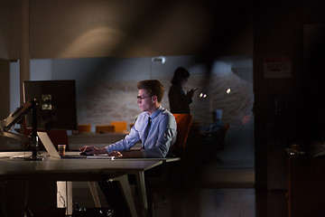 Image showing man working on computer in dark office