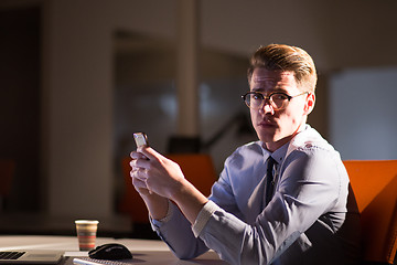 Image showing man using mobile phone in dark office