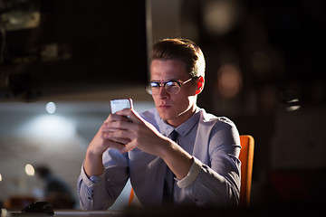 Image showing man using mobile phone in dark office