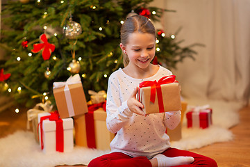 Image showing smiling girl with christmas gift at home