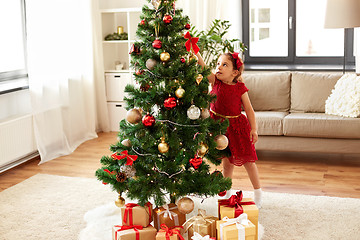 Image showing little girl decorating christmas tree at home