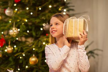 Image showing smiling girl with christmas gift at home