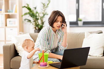 Image showing working mother with baby calling on smartphone