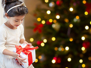 Image showing happy little girl with christmas gift at home