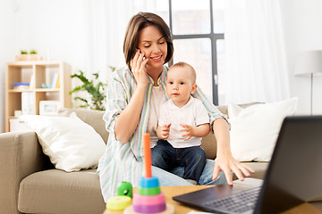 Image showing working mother with baby calling on smartphone