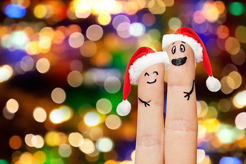 Image showing finger couple in santa hats over lights