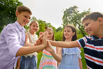 Image showing group of happy kids making high five outdoors