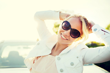 Image showing happy teenage girl or young woman near car