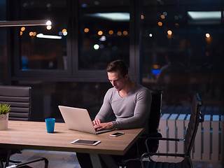 Image showing man working on laptop in dark office