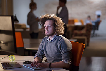 Image showing man working on computer in dark office