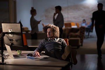 Image showing businessman sitting with legs on desk at office