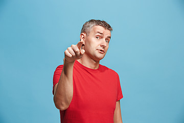 Image showing The serious business man point you and want you, half length closeup portrait on blue background.