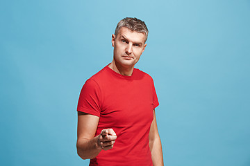 Image showing The serious business man point you and want you, half length closeup portrait on blue background.