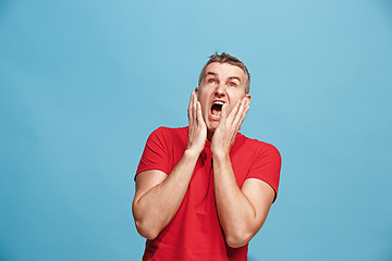 Image showing The young attractive man looking suprised isolated on blue