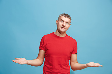 Image showing The happy business man standing and smiling against blue background.