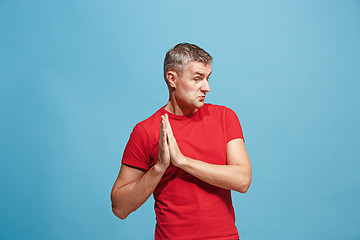 Image showing The happy business man standing and smiling against blue background.