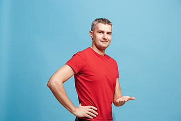 Image showing The happy business man standing and smiling against blue background.