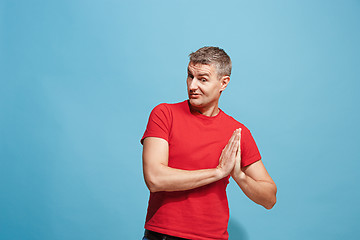 Image showing The happy business man standing and smiling against blue background.