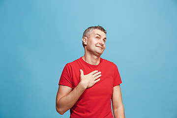 Image showing The happy business man standing and smiling against blue background.