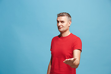 Image showing The happy business man standing and smiling against blue background.