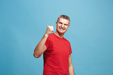 Image showing The happy business man standing and smiling against blue background.