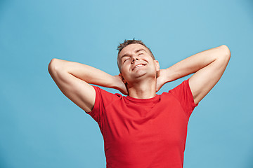 Image showing The happy business man standing and smiling against blue background.