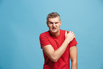 Image showing Young man overwhelmed with a pain in the shoulder