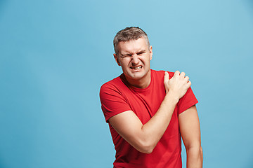 Image showing Young man overwhelmed with a pain in the shoulder