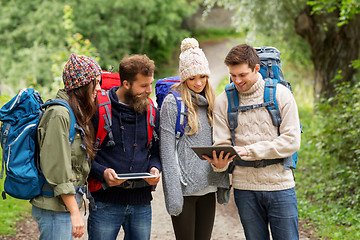 Image showing friends or travelers with backpacks and tablet pc