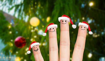 Image showing fingers in santa hats over christmas tree