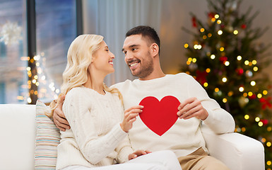 Image showing happy couple with red heart at home on christmas