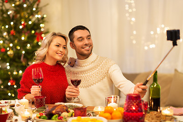 Image showing couple taking picture by selfie stick at christmas