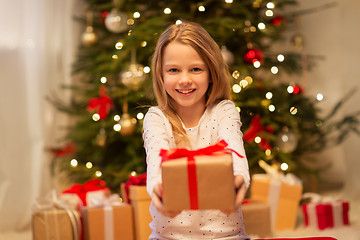 Image showing smiling girl with christmas gift at home