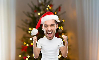 Image showing man celebrating victory over christmas tree