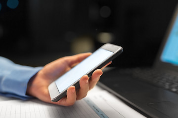 Image showing close up of hand with smartphone at night office