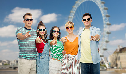 Image showing friends pointing at you over ferry wheel in london