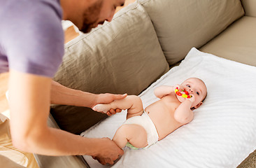 Image showing close up of father and baby with rattle