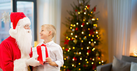 Image showing boy and santa with christmas gifts at home
