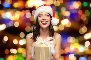 Image showing woman in santa hat with christmas gift