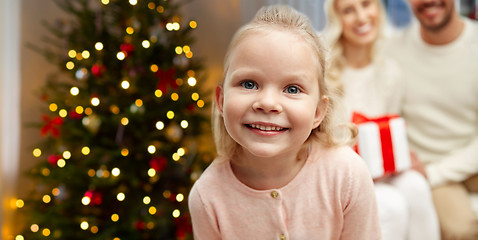 Image showing happy girl with her family over christmas tree